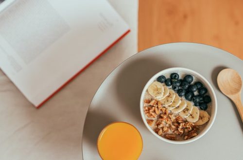 Top view of healthy breakfast with oatmeal, fresh fruit, and orange juice on a tray.